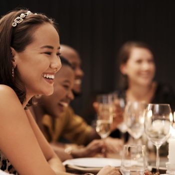 Shot of an attractive young woman sitting and enjoying a New Years dinner party with friends.